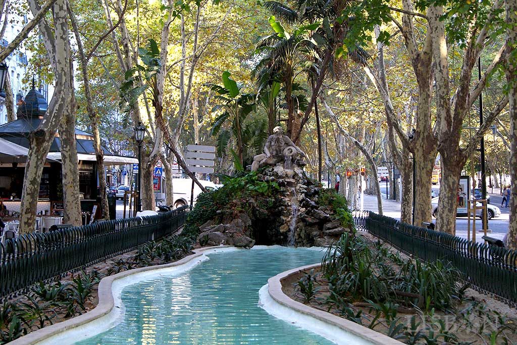 A serpentine pond with a waterfall on its north end. This waterfall features a stone sculpture of a long-bearded masculine figure holding a pot from where the water is flowing. This sculpture represents the Douro River