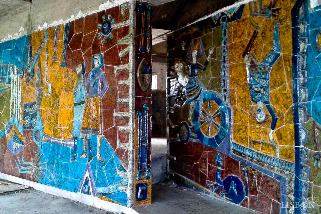 5 Relief Ceramic Panels in Lisbon: Ceramic panel in Panorâmico de Monsanto Viewpoint, by Manuela Madureira. In an alternation of two-dimensional elements and reliefs, abstract shapes, figures and scenes related to the city of Lisbon are represented, such as boats, closely linked to the Tagus river. The colours are predominantly blue tones contrasting with ochre, brown and orange.