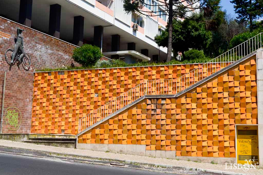 Ceramic panel by Eduardo Nery, Infante Santo Avenue. The use of ceramic slabs of three orange tones in a wedge shape allows different ways of placing them. Together with the reflection of light and the position of the observer, it creates unique visual effects.