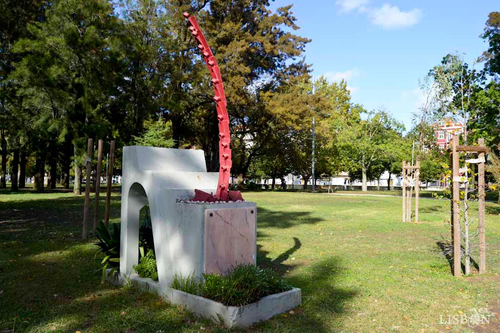  This abstract sculpture from 1985 is from Soares Branco (1925-2013) and the plinth from the architect Eduardo Martins Bairrada (1930-1987). The sculpture is composed of different materials, among them hoe blades that form an arch, symbolising the movement and strength with whom the gardener works the soil for plantation.