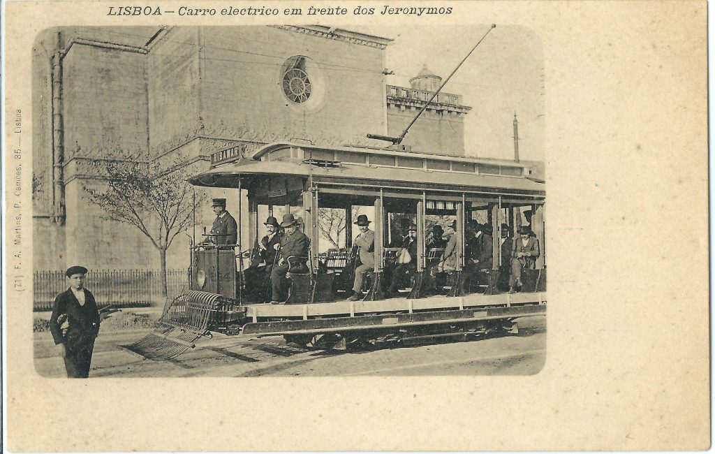 Postcard of a tram with destination to Ribamar-Algés, in front of Jerónimos Monastery. The first Lisbon trams had an open coachwork with a roof supported on pillars between which there were striped canvas blinds. It was a surprising fact that these vehicles were bidirectional.