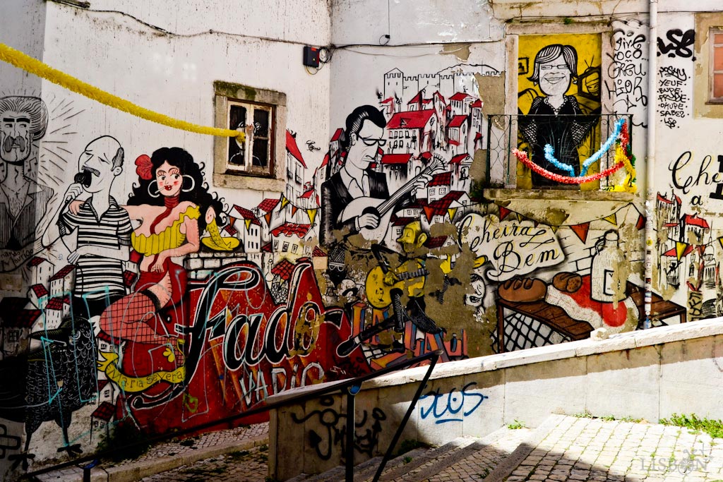 O Fado na Arte Urbana de Lisboa: Mural Fado Vadio, localizado nas Escadinhas de São Cristóvão, no bairro da Mouraria. Este expressivo mural é rico não só em referências ao fado, mas também a símbolos e vivências deste bairro e da própria cidade.