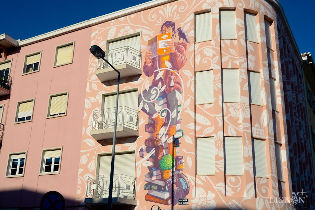 Mural Menina e Moça, em homenagem a Carlos do Carmo de Mário Belém. Nesta pintura, a “menina e moça”, sentada sobre uma pilha de livros, tem um livro aberto entre as mãos e ao ombro o corvo da cidade. Fazem ainda parte da composição outros símbolos de Lisboa como uma varina, o Santo António, um manjerico, um eléctrico,… e pelo meio um disco em vinil do Carlos do Carmo.