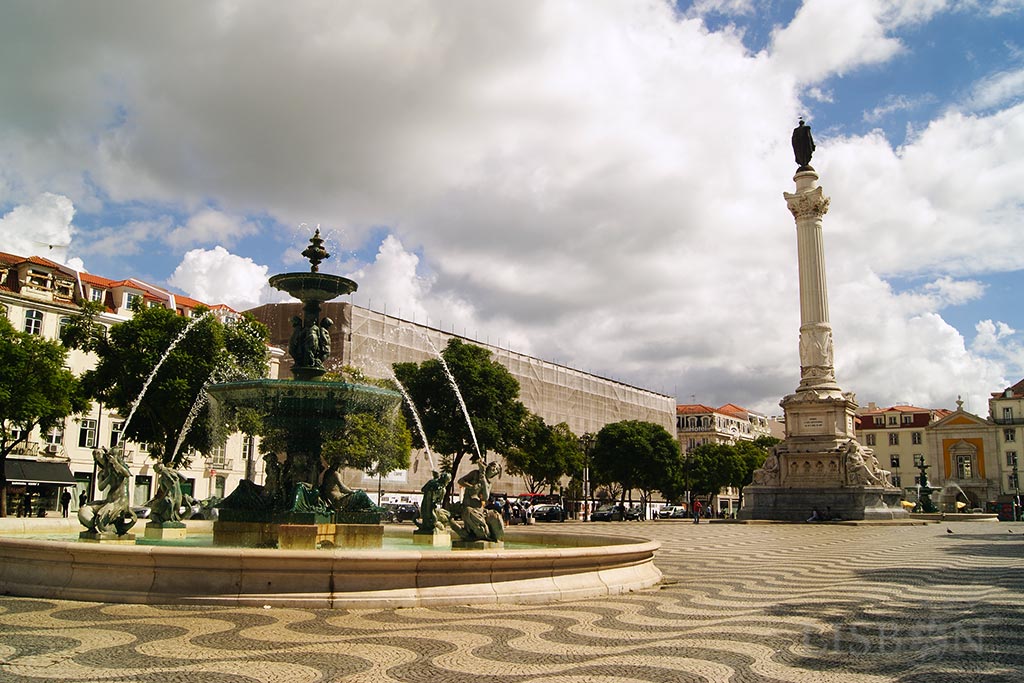 Panorâmica do Rossio onde são visíveis as duas fontes monumentais idênticas que ladeiam o monumento de homenagem a D. Pedro IV, no centro da praça