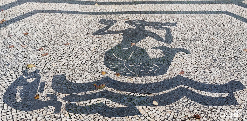 animais e seres fantásticos na calçada portuguesa: em redor do monumento ao poeta Luís de Camões podemos observar mais exemplos de animais e seres fantásticos na calçada portuguesa de Lisboa: quatro reproduções de uma sereia sobre ondulações de onde emerge um peixe