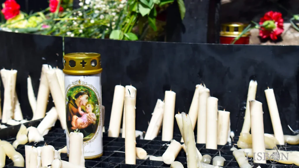 Devotional candles surrounding the statue of Saint Anthony in Largo de Santo António da Sé